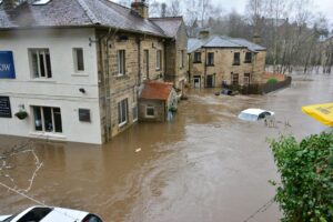 Rue inondée au cœur d’une ville, voiture partiellement submergée