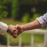 Poignée de main entre deux personnes en extérieur