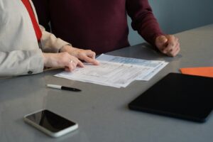 Deux personnes relisent des documents de travail autour d’une table